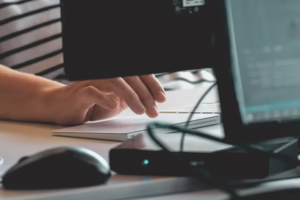 Scrivania con schermo che mostra una casella di posta mano ferma sul mouse