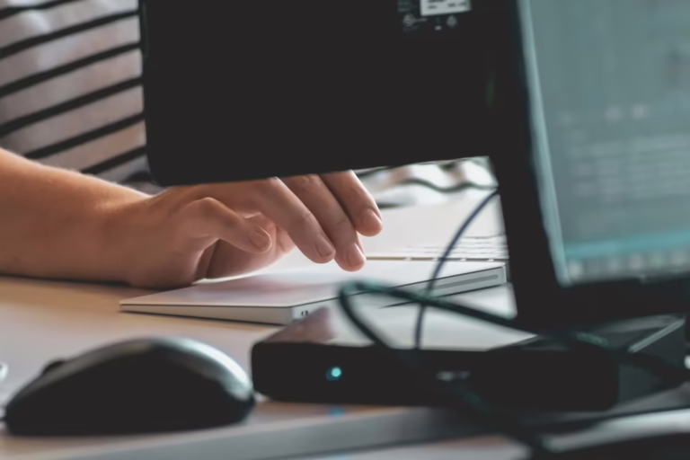 Scrivania con schermo che mostra una casella di posta mano ferma sul mouse
