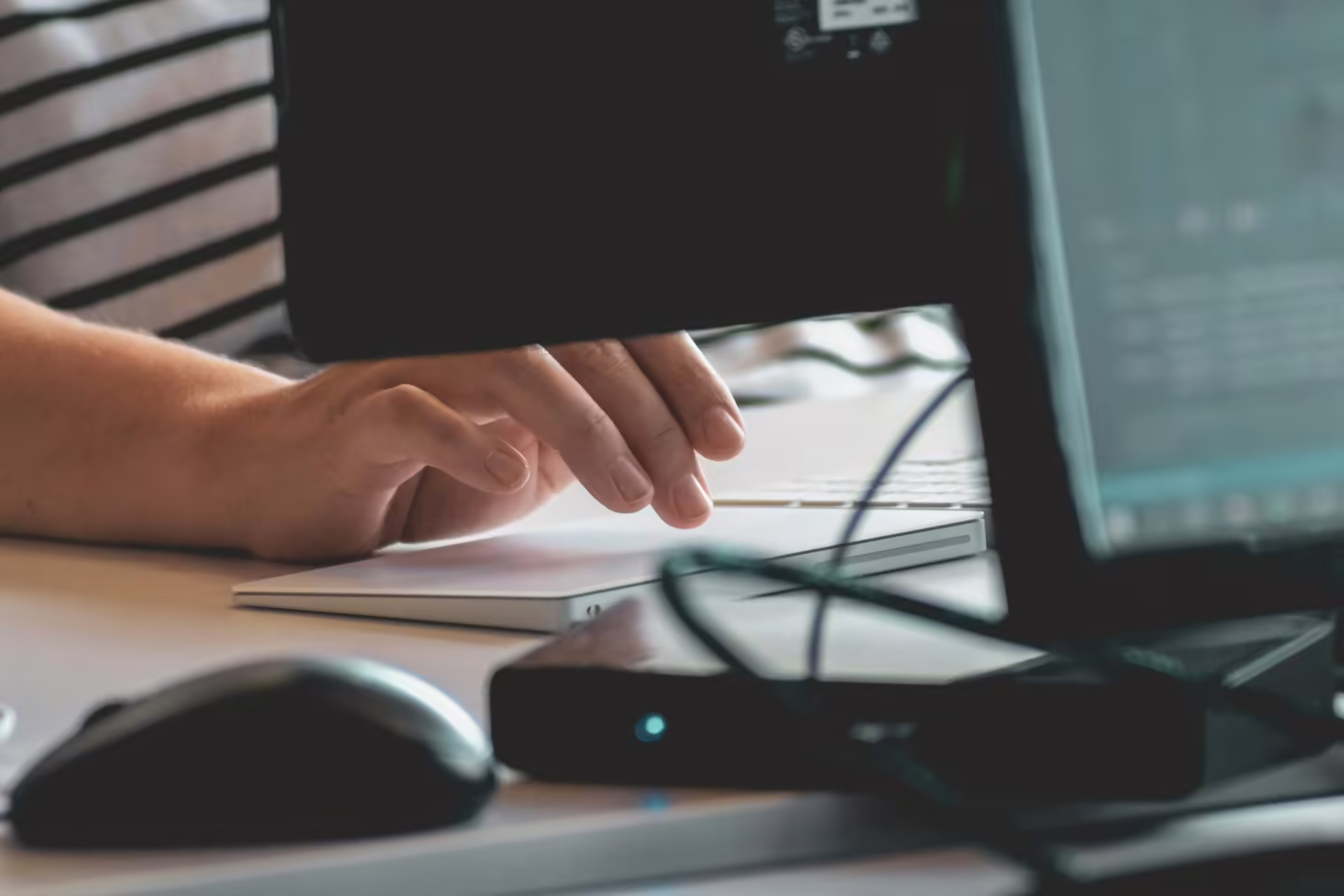 Scrivania con schermo che mostra una casella di posta mano ferma sul mouse